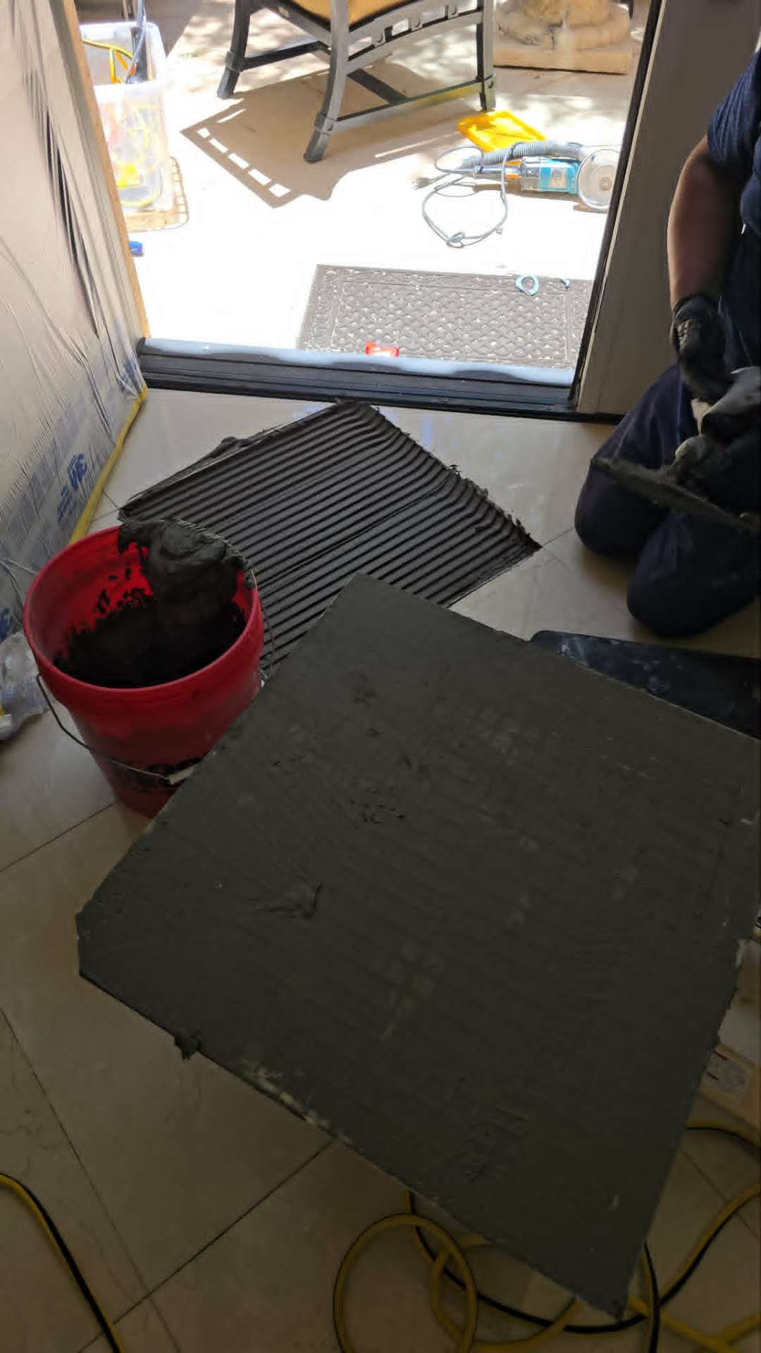 The Top 3 Reasons New East Valley Builds Are Failing in 3 Years (And How to Stop It Before Your Builder Warranty Expires) Properly combed mortar bed with directional troweling on a prepared subfloor before tile installation in an Arizona new construction home showing the correct full coverage technique that prevents hollow tile failure
