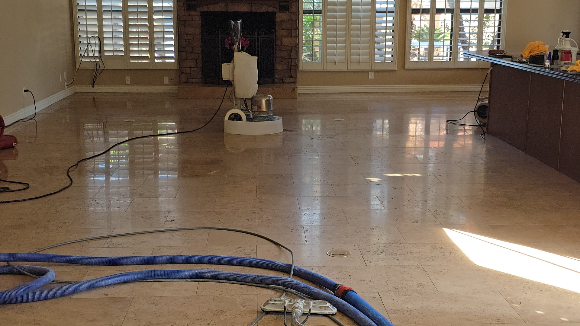 Travertine floor polishing in progress at Ahwatukee Foothills home with grinding equipment